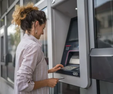 Výběr hotovosti z kreditní karty se může prodražit i u vlastního bankomatu. Zdroj Žena u bankomatu