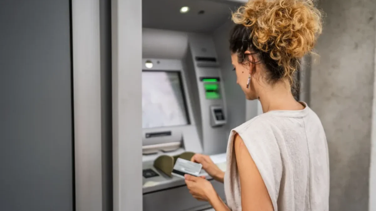 Žena vybírá peníze z bankomatu