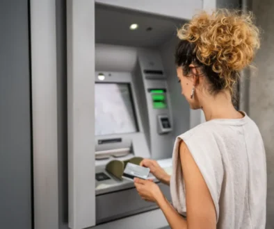 Žena vybírá peníze z bankomatu