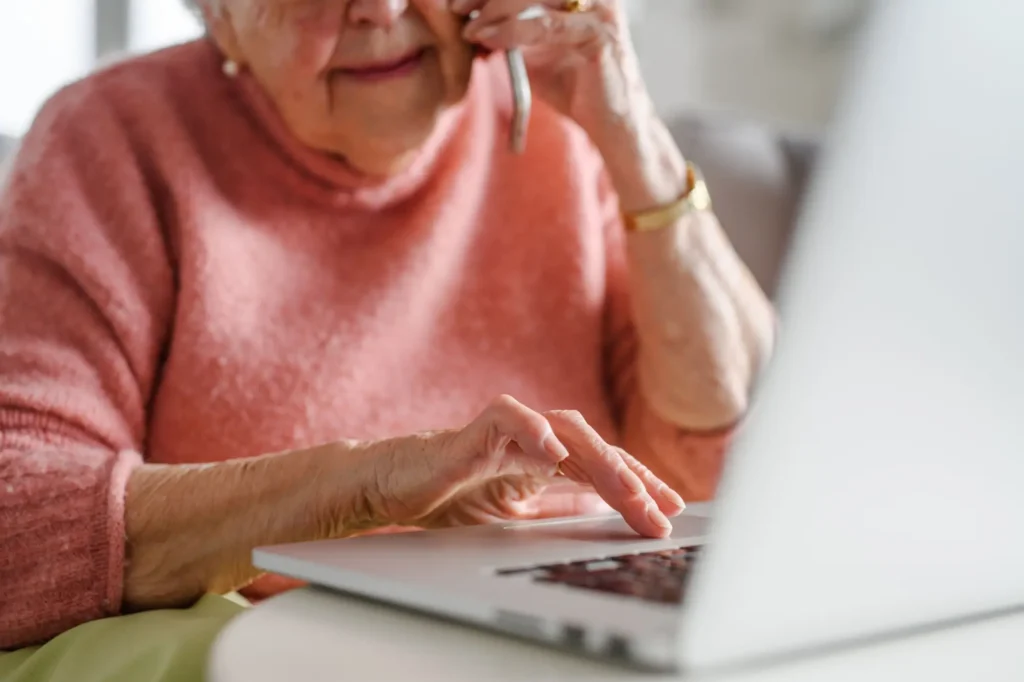 Seniorka s počítačem a mobilem