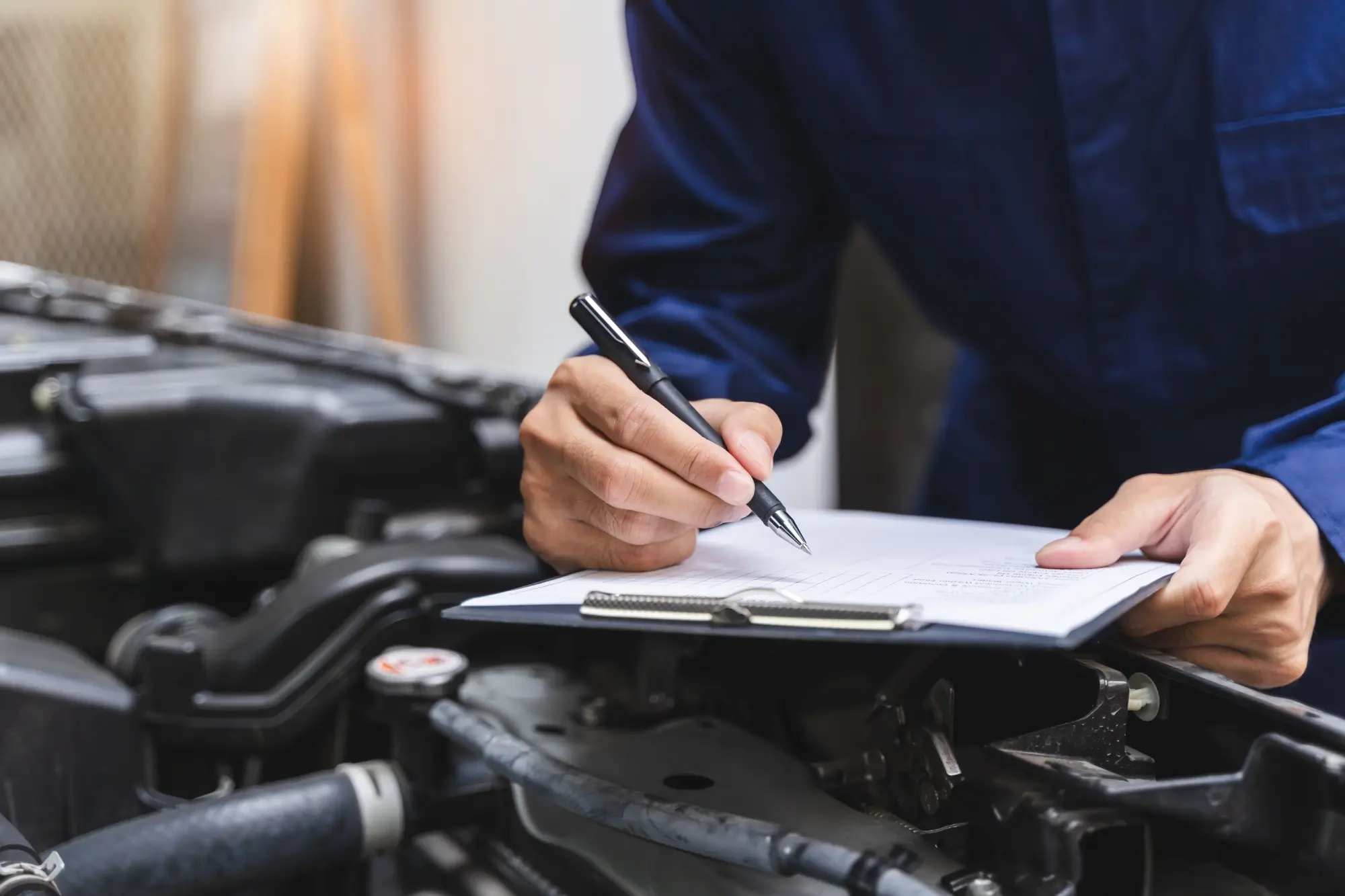 zaměstnanec autoservisu kontroluje auto