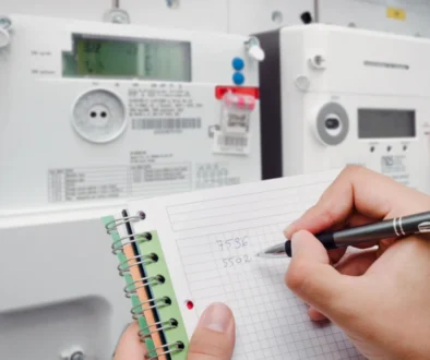 Osoba si zapisuje stav vysokého a nízkého tarifu na svém elektroměru