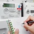 Osoba si zapisuje stav vysokého a nízkého tarifu na svém elektroměru