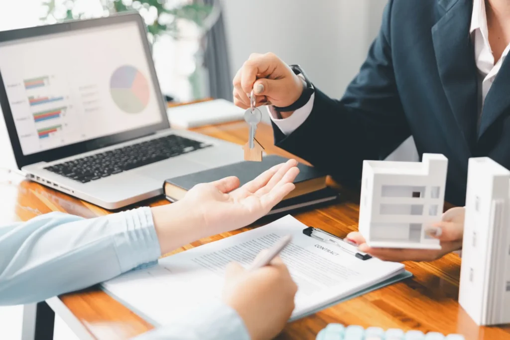 Shutterstock_2632670891 - Techsvět Obchodní jednání při koupi investiční nemovitosti, dva lidé si podávají klíče od domu po uzavření dohody