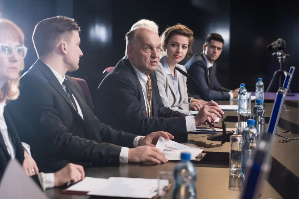 lidé v oblecích se dohadují na konferenci