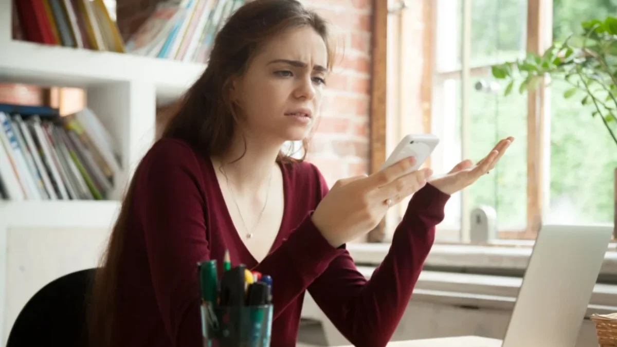 žena se rozčiluje nad telefonem, který se opět seká a nejde jí messenger