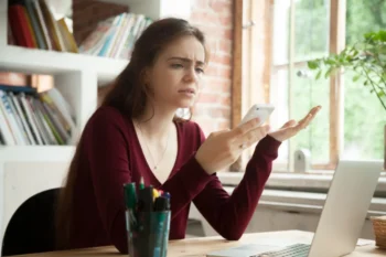 žena se rozčiluje nad telefonem, který se opět seká a nejde jí messenger