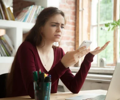 žena se rozčiluje nad telefonem, který se opět seká a nejde jí messenger