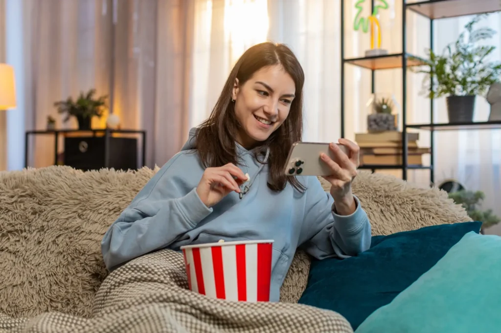 Žena sleduje film na mobilu