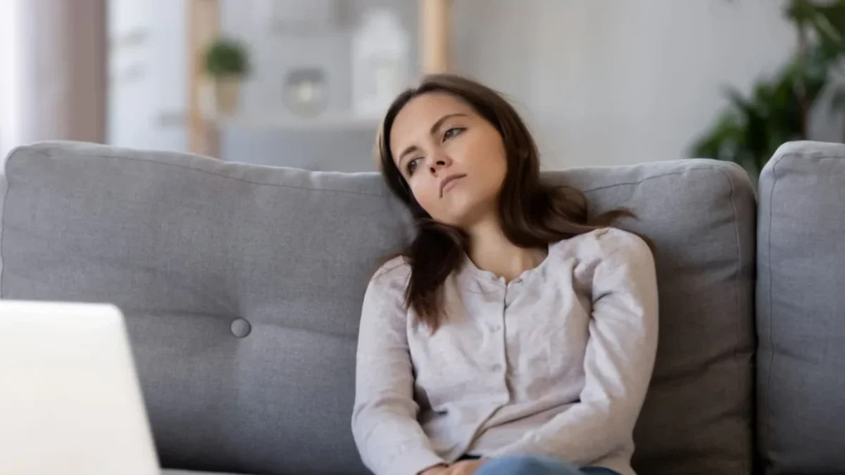 zamyšlená žena sedí u počítače