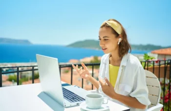 Žena s notebookem a sluchátky na dovolené