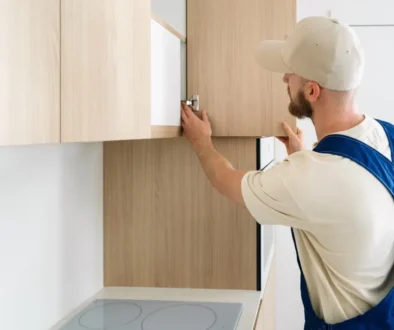 řemeslník spravuje dvířka od kuchyňské skříňky