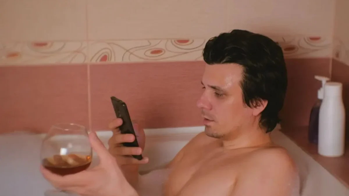 muž s telefonem ve vaně