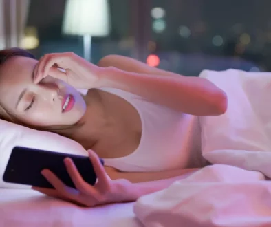 Unavená žena s mobilem v posteli