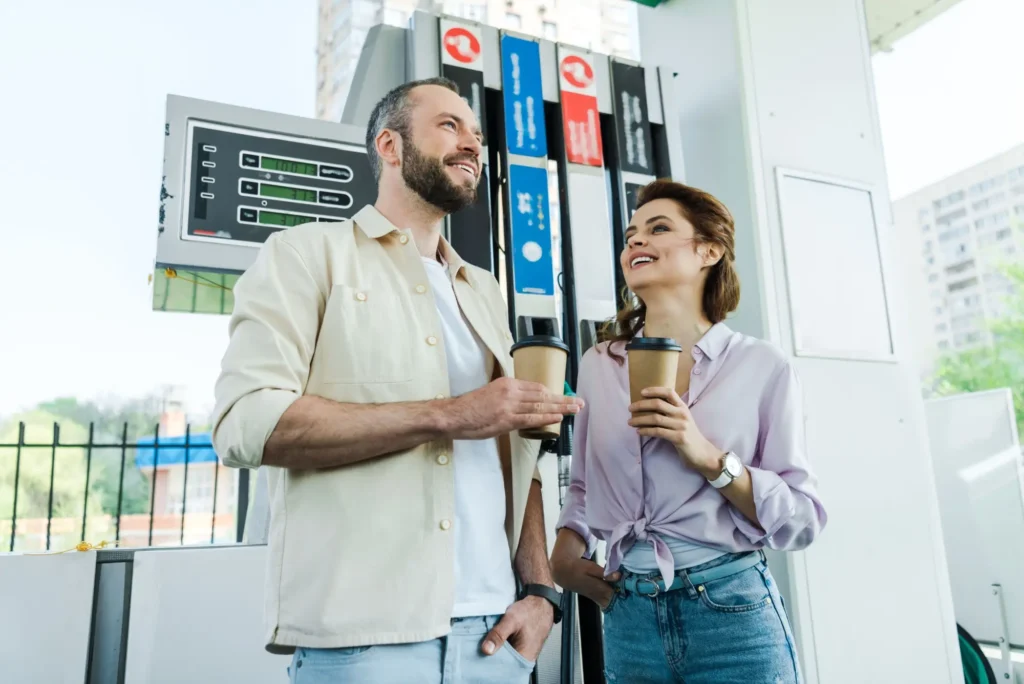 muž a žena pijí u benzinky kávu