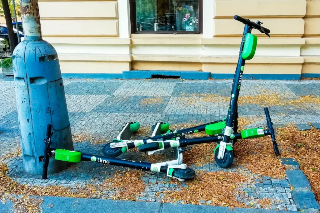 Na ulici v Praze jsou na hromadě pohozené elektrokoloběžky.