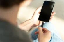 Muž připojuje mobil do nabíječky