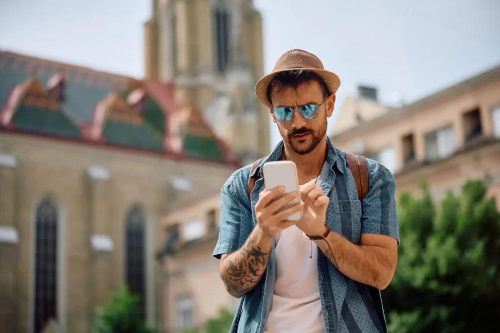 turista něco hledá v telefonu během dovolené