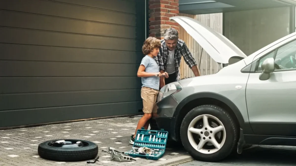 otec se synem dělají servis na svém autě doma