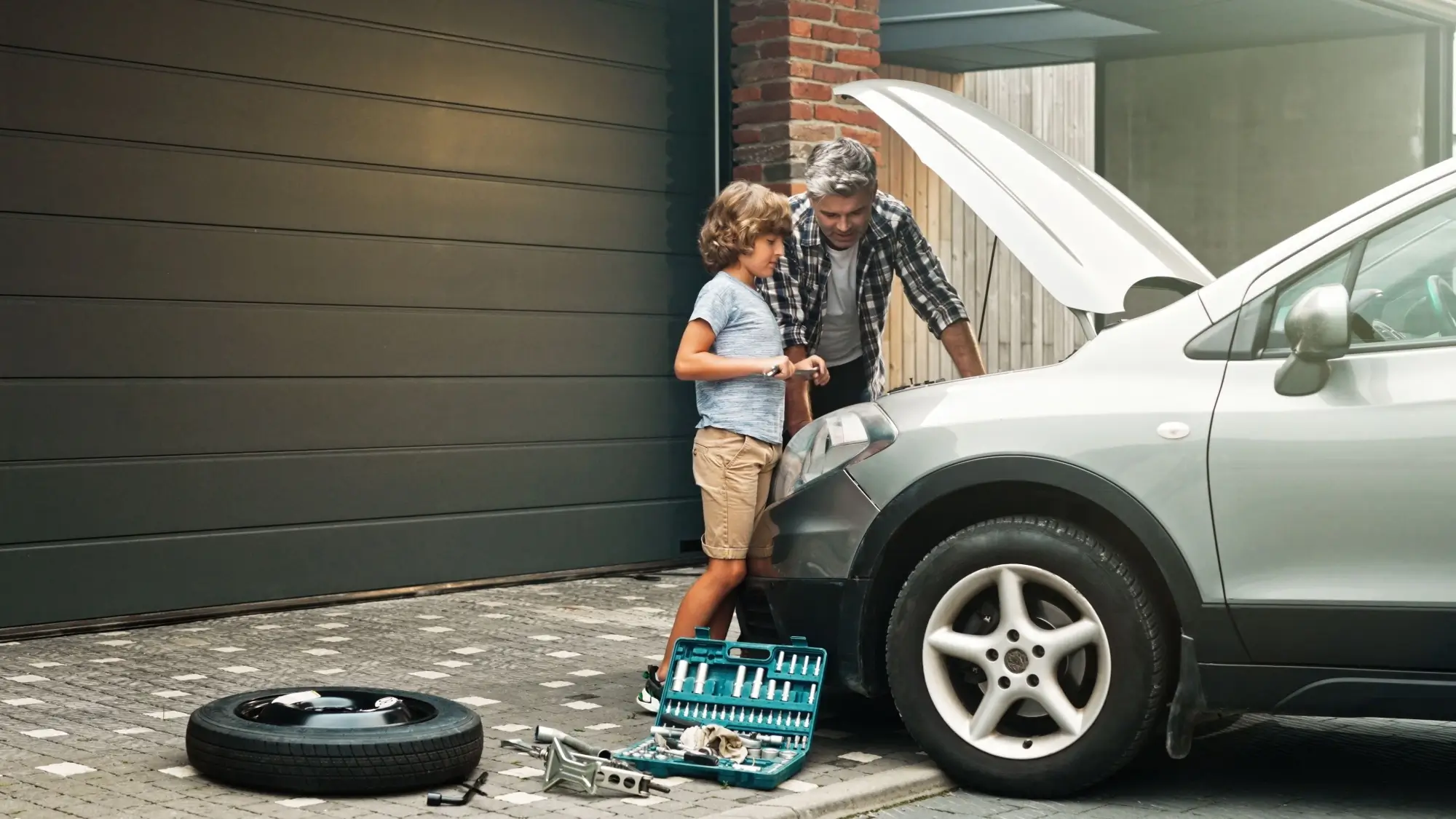 otec se synem dělají servis na svém autě doma