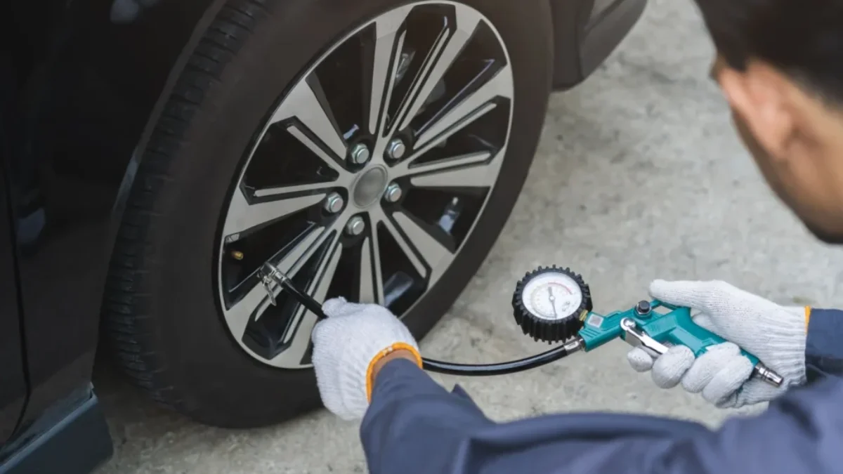 Muž měří tlak pneumatik