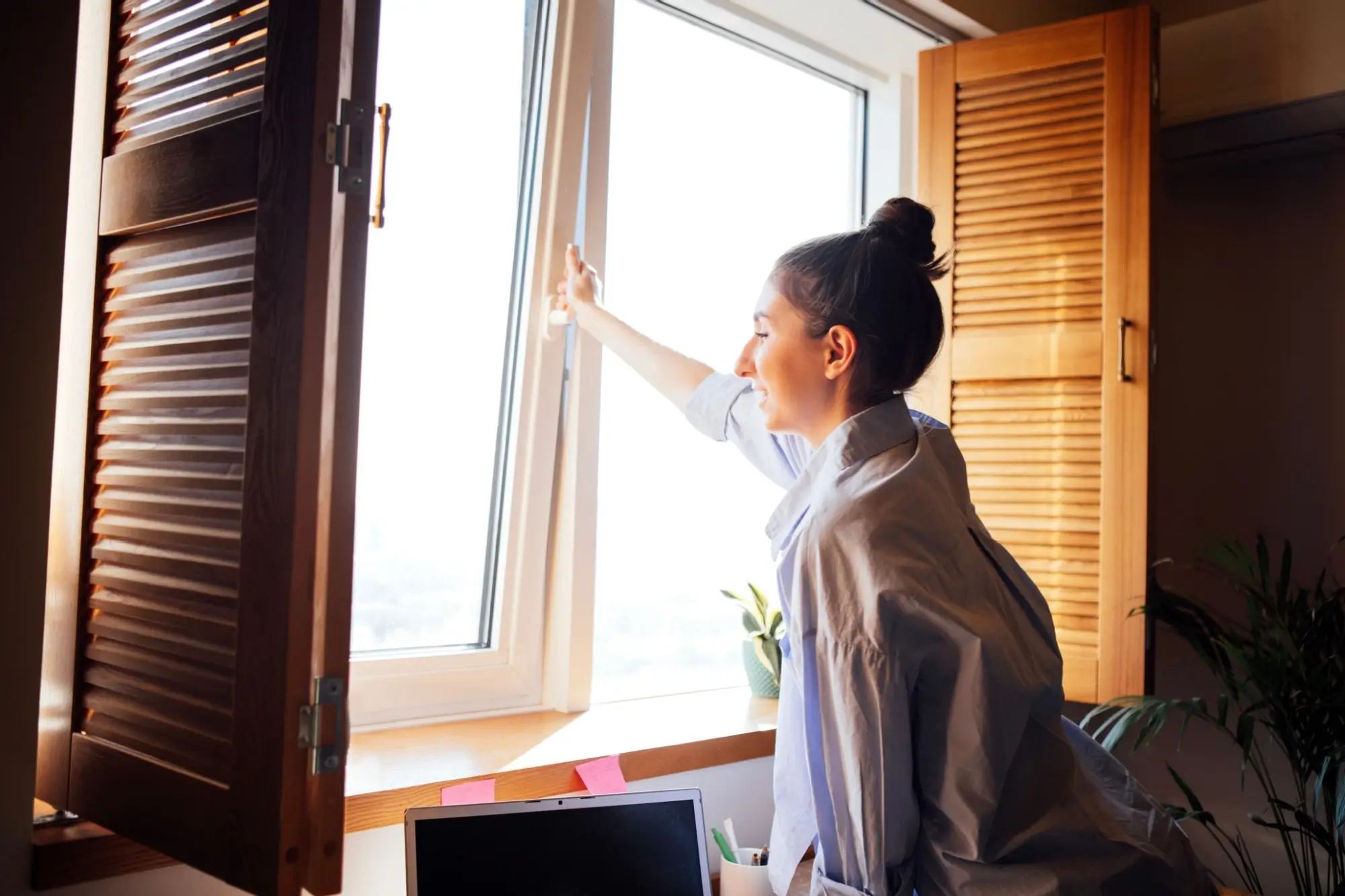 Žena otvírá okna
