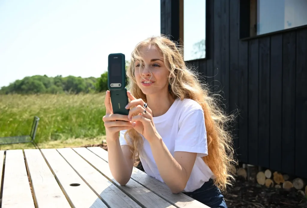 profimedia-0783995320 1 - Techsvět Žena sedí na lavičce a používá zelený rozkládací telefon