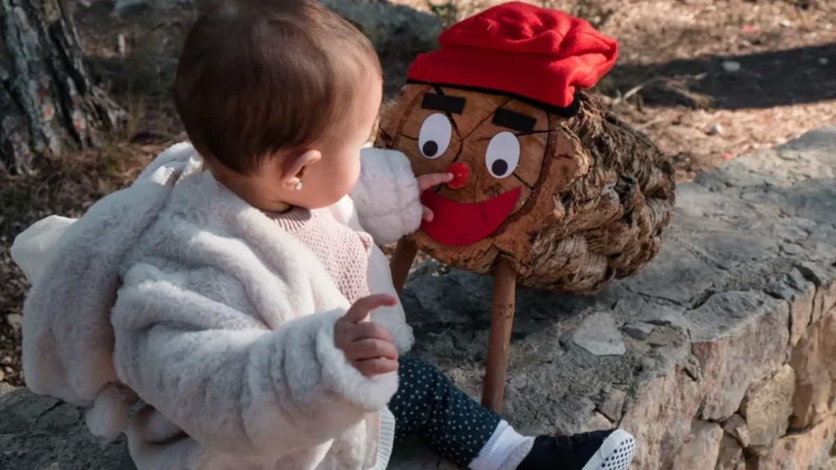 malé dítě sahá na Tió de Nadal