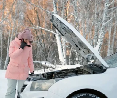 Žena u porouchaného vozu v zimní krajině