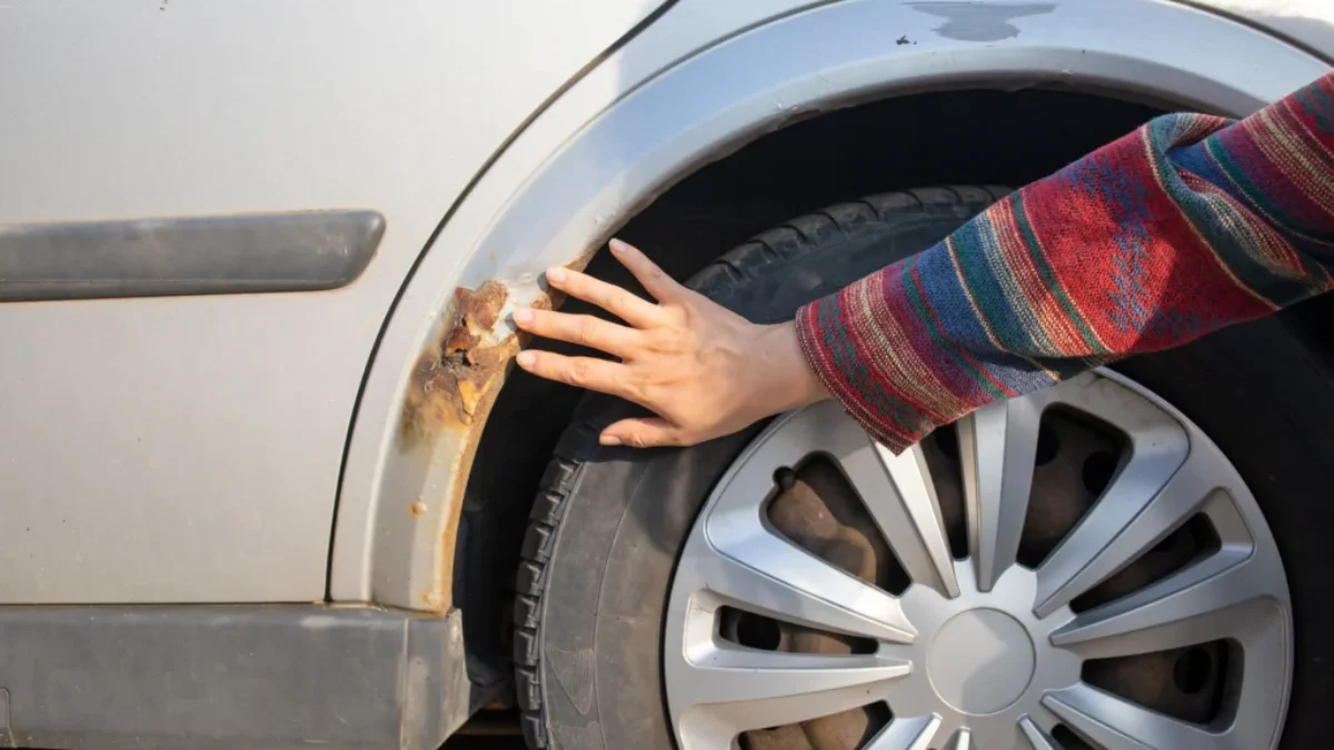 Žena kontroluje korozi blatníku.