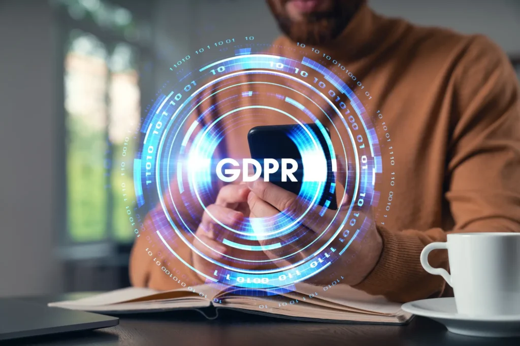 Muž držící telefon a grafika GDPR