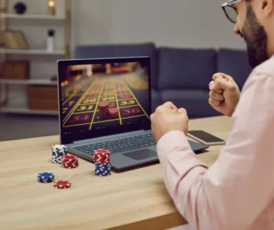 Muž sedí před notebookem a sleduje výsledky hry v casinu