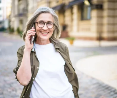 Staří žena volá mobilem a usmívá se