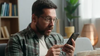 Muž v šoku při pohledu zjištění určitých informací na telefonu