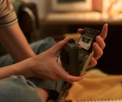 Zátiší s retro technologiemi z 90. let, jako jsou kazety, staré telefony a herní konzole.