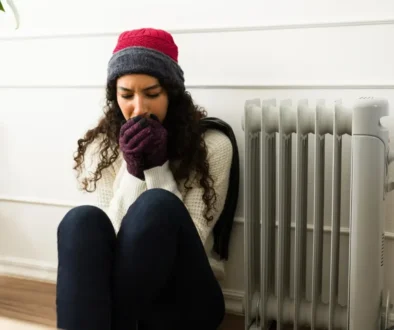 vypnuté topení, mladá žena ve svetru se třese zimou