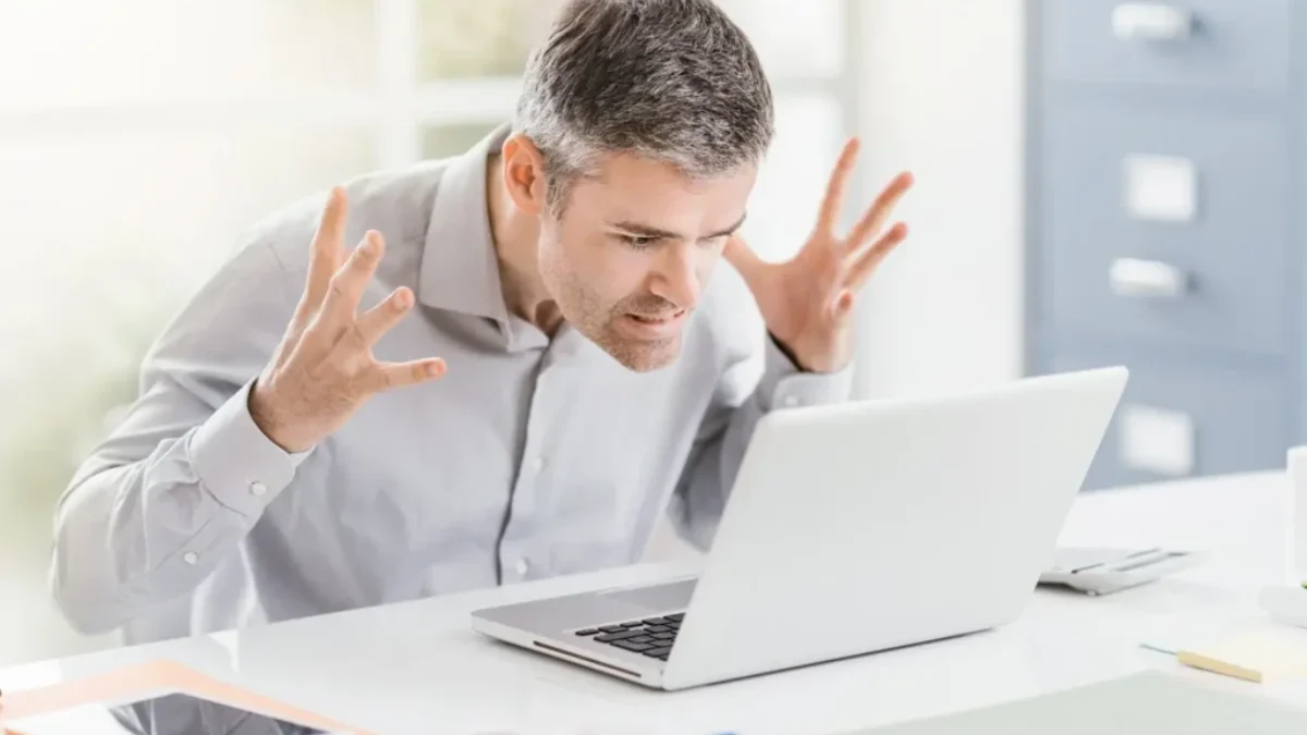 muž se vzteká u notebooku