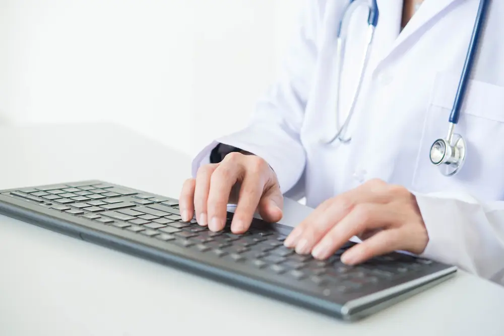 Lékař zadává neschopenku do systému