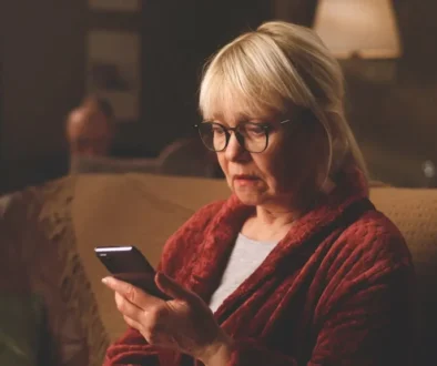 zděšená žena čte zprávu na mobilu