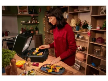 žena v kuchyni používá horkovzdušnou fritézu s grilem