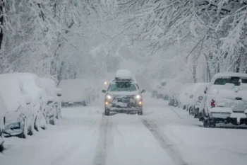 auto na zasněžené silnici mezi stromy