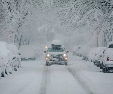 auto na zasněžené silnici mezi stromy