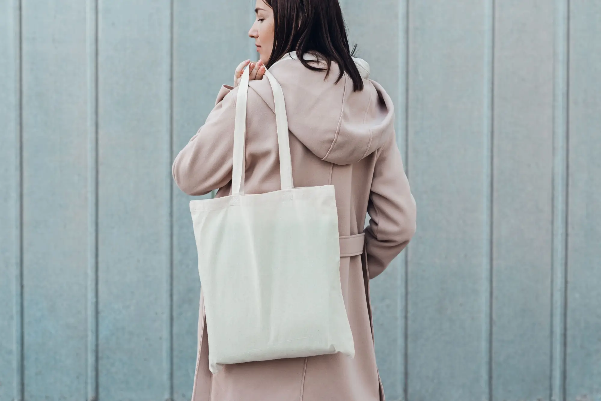 Žena drží v ruce plátěnou tašku