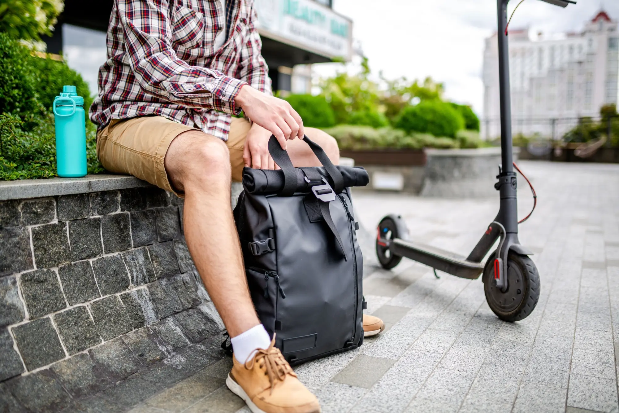 Muž sedí ve městě s batohem