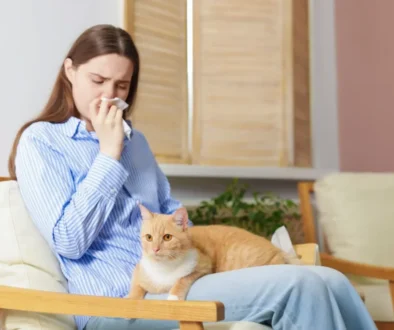 Žena kýchá a má kočku na klíně