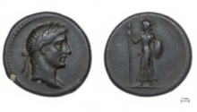 Ancient coin with a left-facing male head (obverse) and a standing female figure with spear and shield (reverse); scale shows 1 mm.