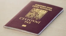 Czech passport with gold crest on a maroon cover resting on a light surface, close-up view