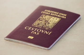 Czech passport with gold crest on a maroon cover resting on a light surface, close-up view
