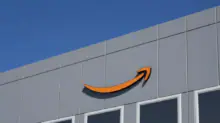 Amazon logo on the gray exterior of a building against a clear blue sky