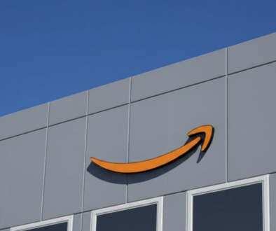 Amazon logo on the gray exterior of a building against a clear blue sky